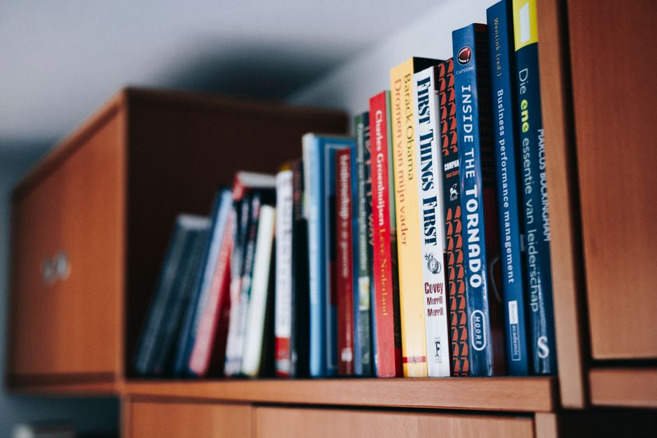 A close-up of a stack of open books with pages fanned out, capturing a study atmosphere.