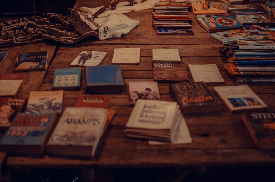 From above of various books and stack of magazines placed on shabby wooden table