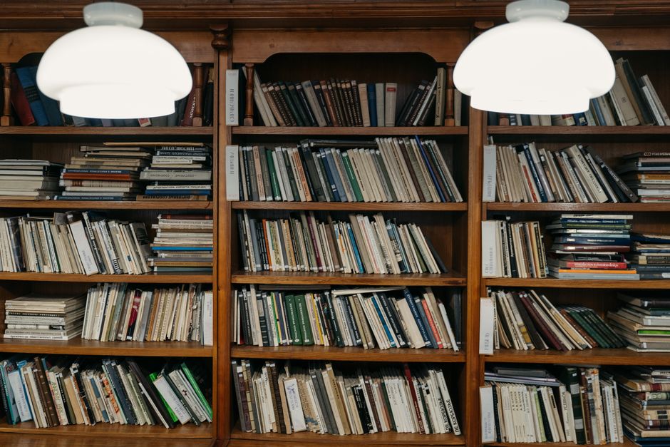 From above of various books and stack of magazines placed on shabby wooden table