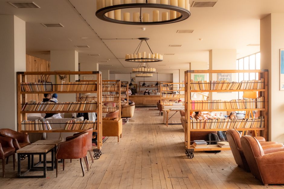 Warm and inviting library interior in Stepantsminda, Georgia with wooden bookshelves and leather chairs.